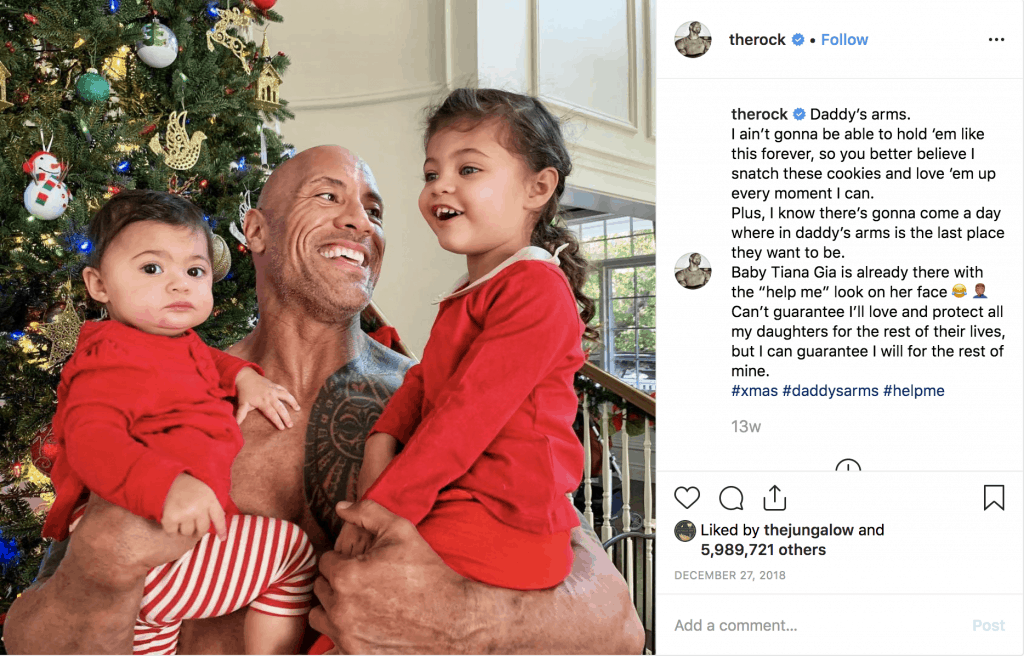 The Rock holding his daughters